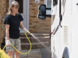 A person rinsing down a motorhome