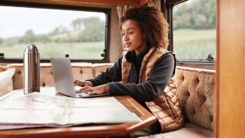 A woman on a laptop in a campervan
