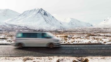 A campervan driving past Glencoe in winter